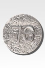 A silver disc with a textured surface, inspired by Cast Aluminum Lot Markers, is engraved with the number "76" against a pristine white background.