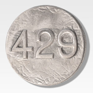 Close-up of a textured silver coin with the number "429" embossed on its surface, featuring a robust design reminiscent of Cast Aluminum Lot Markers.