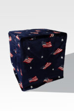 The EZ Fold Cremation Stand, with its sleek, space-saving design, pairs perfectly with a cube-shaped pouf featuring dark fabric adorned with American flag and star patterns.