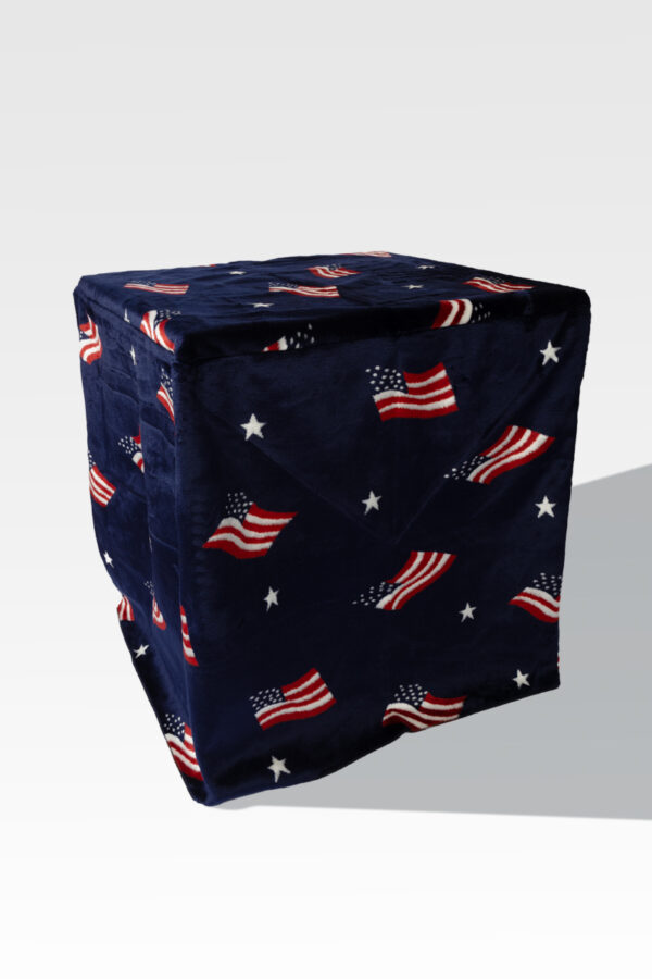 The EZ Fold Cremation Stand, with its sleek, space-saving design, pairs perfectly with a cube-shaped pouf featuring dark fabric adorned with American flag and star patterns.