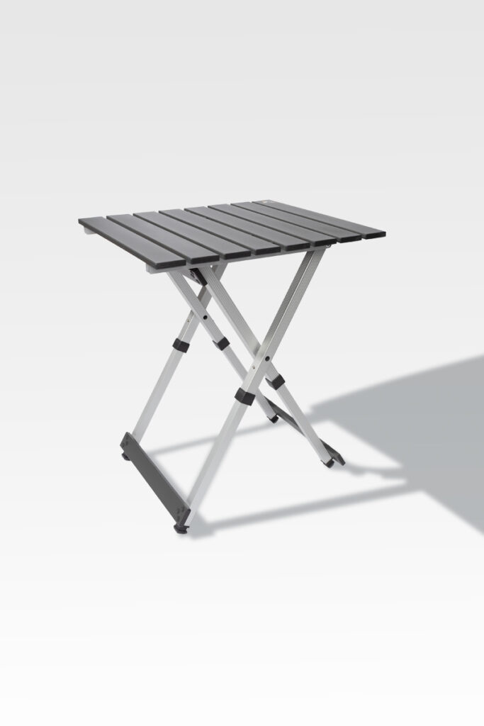 The EZ Fold Cremation Stand is a compact, foldable gray metal table with a slatted top and X-shaped legs, displayed on a light gray background.