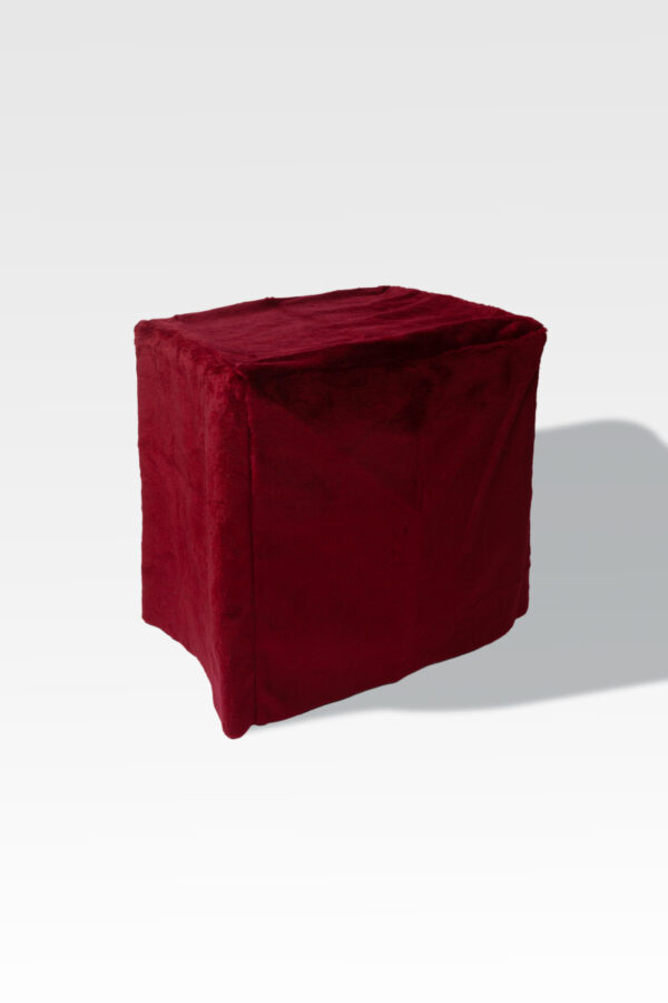 A plush red velvet cube ottoman, similar in shape to the EZ Fold Cremation Stand, stands elegantly against a simple gray background.