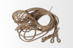 A brown coiled product called "Guy Ropes" with three looped ends elegantly rests on a light gray background.