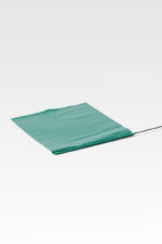 A folded green tarp partially extended on a smooth, light gray surface akin to that of Grave Identification Flags.