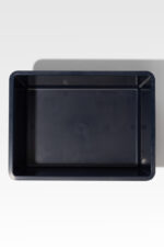 A Safeguard® Urn Vault, empty and black in its rectangular form, stands out starkly against a light background.