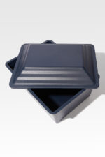 The Safeguard® Urn Vault, a dark gray, square metal container with a matching lid and sturdy design, is depicted open on a light background.