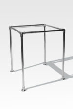 The Stainless Steel Cremation Stand features a sleek, metallic square frame with four sturdy legs, elegantly captured on a light gray background.