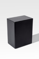 A black, rectangular, solid block from the Temporary Cremation Containers collection is placed against a plain white background.