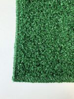 Close-up of the corner of a Graveside Grass mat, showing its textured green surface against a white background.