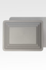 A rectangular, gray, textured plastic tray with a raised border, viewed from above on a light background.
