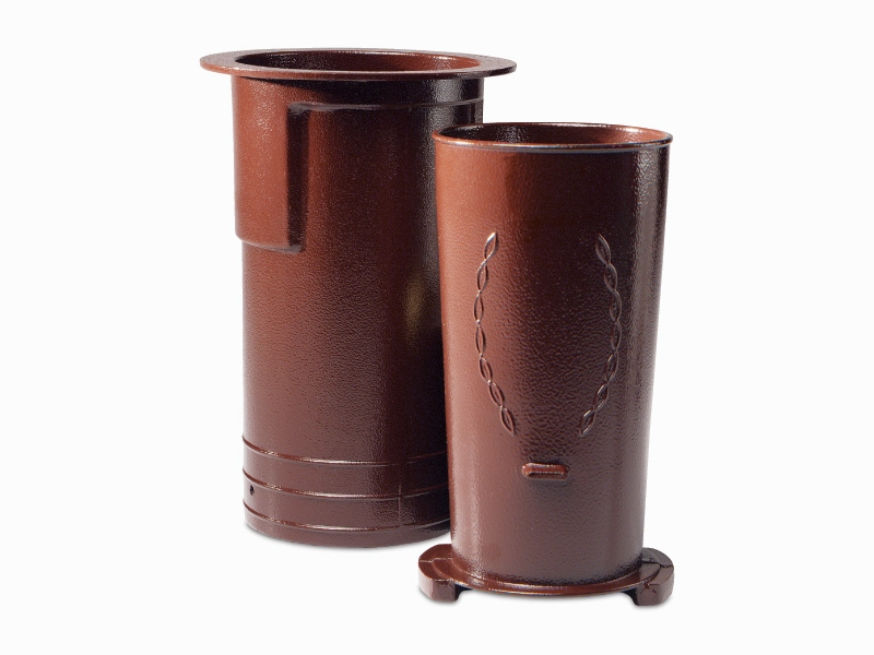 Two brown cylindrical objects, reminiscent of a cemetery vase, feature embossed patterns on the side against a white background.