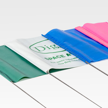Five rectangular plastic flags in green, white, blue, and pink, attached to metal wires, are arranged side by side on a white background.