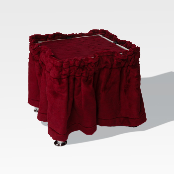 A square stool covered with a deep red, ruffled fabric and standing on four short metal legs, set against a plain light background.