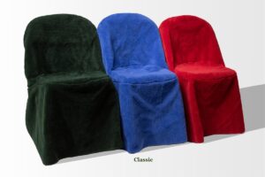 Three chairs covered in plush fabric slipcovers in dark green, blue, and red, labeled "Classic," create an elegant graveside setup against a plain background.