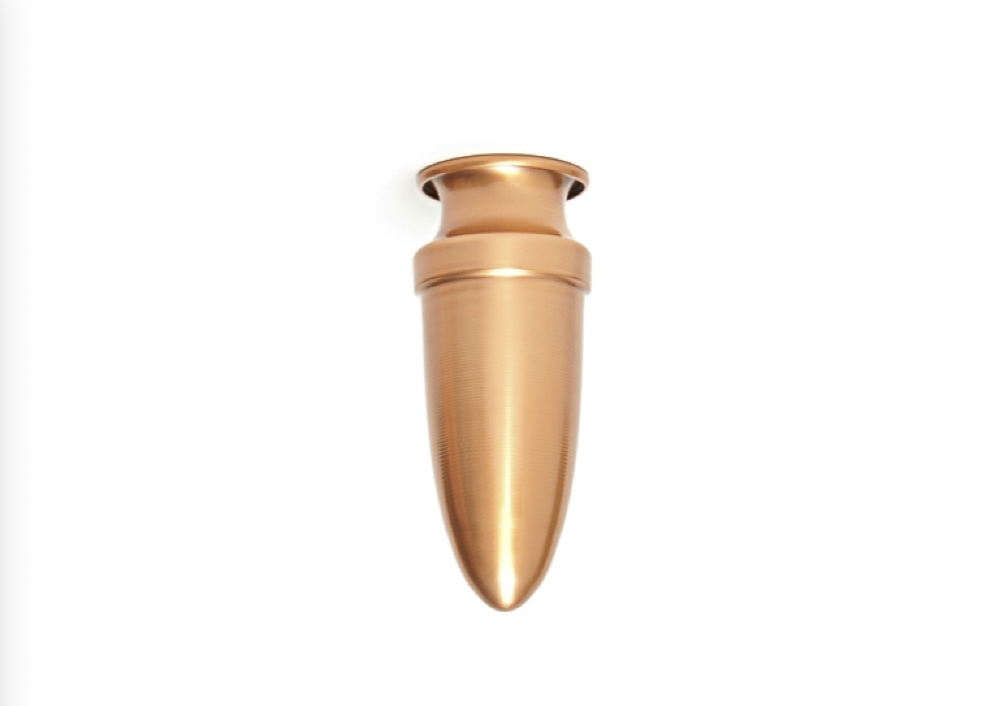 A metallic, bullet-shaped object with a smooth surface and a flared top, photographed against a white background.